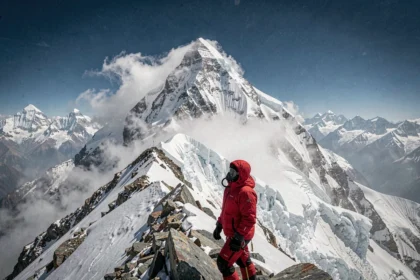 Alpiniste au sommet de l'Everest contemplant le plus haut sommet du monde dans les Himalaya